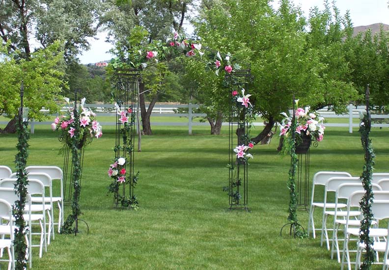 Iron columns used outside with matching aisle post and white chairs Iron columns used outside with matching aisle post and white chairs