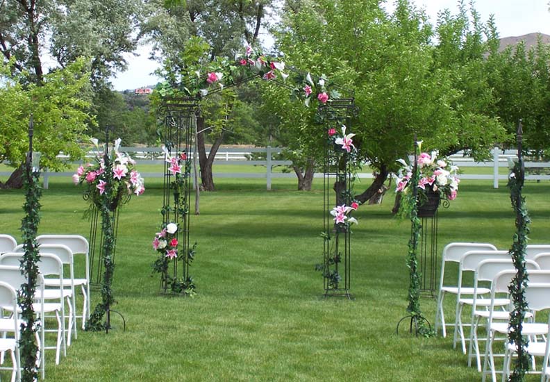 Iron columns used outside with matching aisle post and white chairs