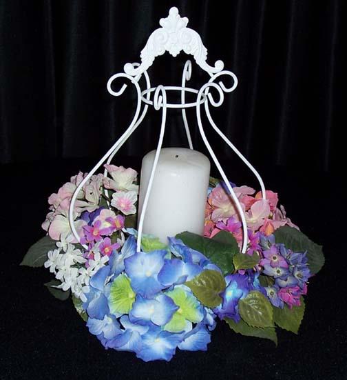 Round white iron cage holds a pillar candle or a flower bouquet